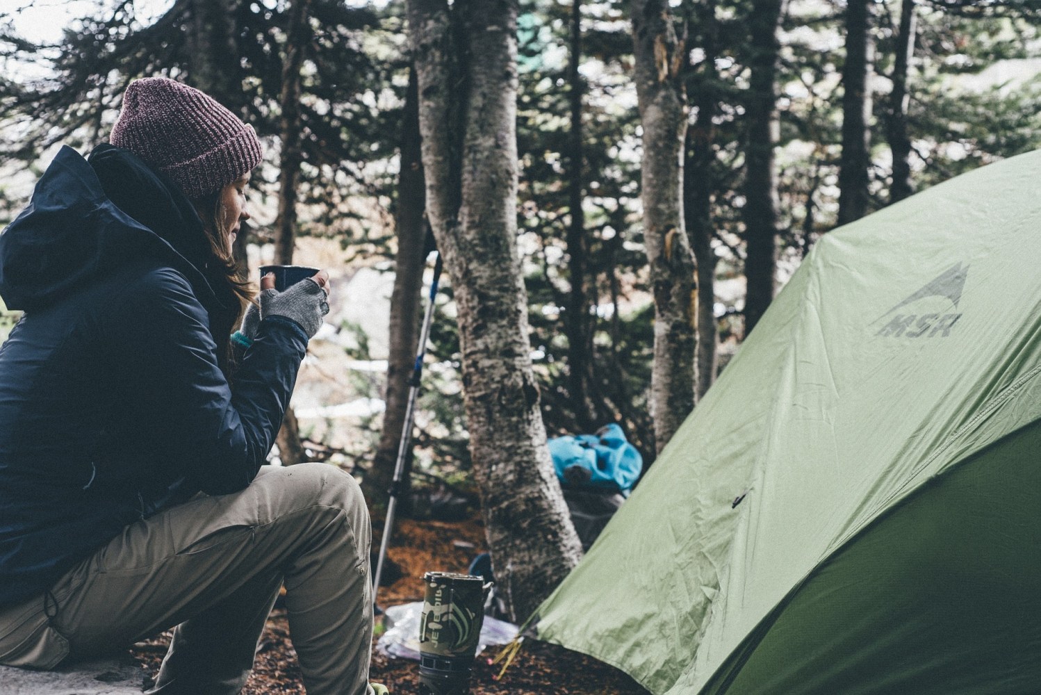 Woman with a cup of coffee camping