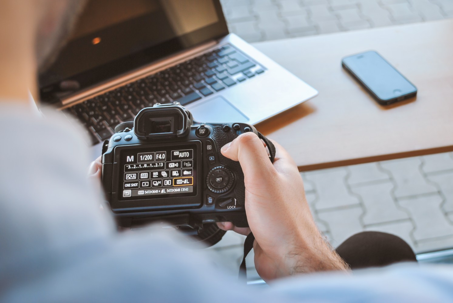 Holding a camera in front of a laptop