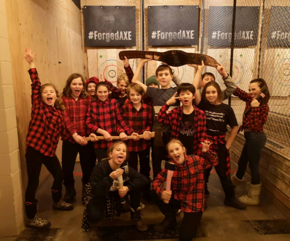 Friends wearing red & black shirts holding axes